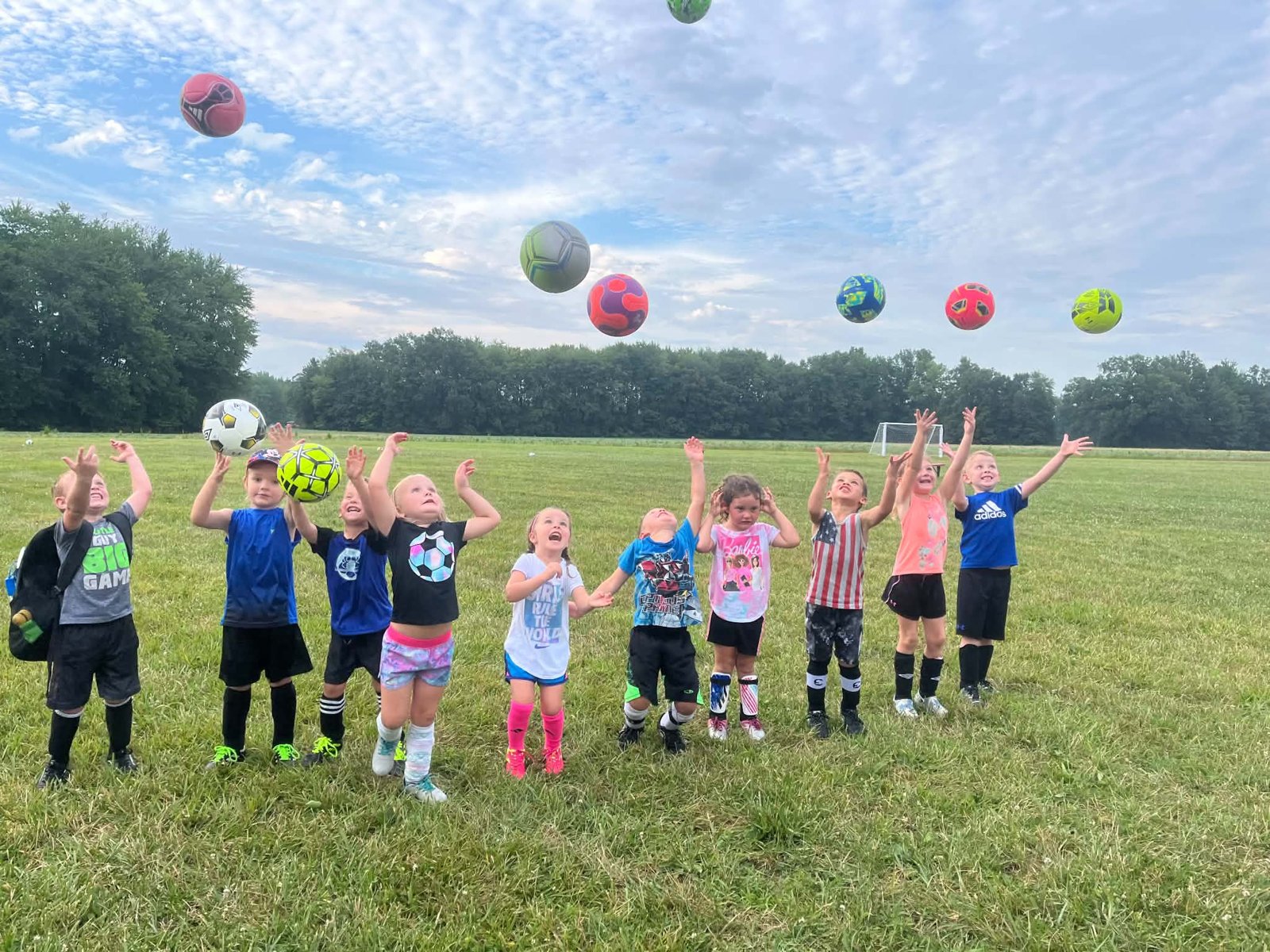 Young Bethel soccer players tossing balls in the air